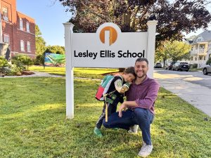 parent posing with their kid on first day of school